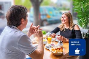 a man and woman sitting at a table eating food at Apart by Broadway in Buenos Aires