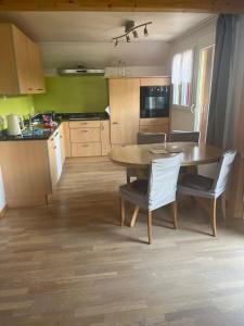 a kitchen with a wooden table and chairs in a room at Landliebi 3-room apartment in Faulensee