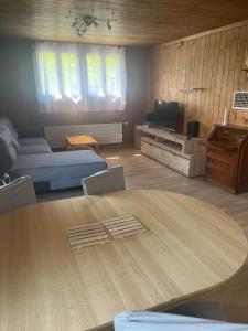 a living room with a table and a couch at Landliebi 3-room apartment in Faulensee