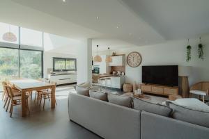 a living room with a couch and a dining room at Villa Ryx avec piscine in Grimaud