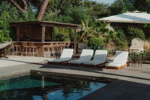 a group of chairs sitting next to a swimming pool at Villa Ryx avec piscine in Grimaud
