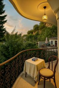 a table and chairs on a balcony with a view at Heritage Rose Inn in Srinagar