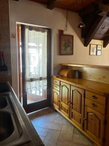 a kitchen with a sink and a door to a window at Bovec Center Stay in Bovec