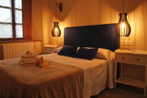 a bedroom with a bed with a cat sitting on it at Mendiko Baserria in Amurrio