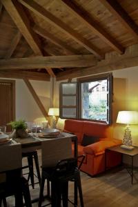 a living room with an orange couch and a table at Mendiko Baserria in Amurrio