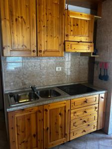 a kitchen with wooden cabinets and a sink at Bovec Center Stay in Bovec