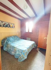 a bedroom with a bed with a blue comforter at Le break vert in Lacapelle-Viescamp