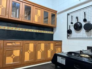 a kitchen with wooden cabinets and pots and pans at Bromo Breeze Malang in Malang