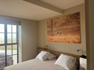 a bedroom with a bed and a painting on the wall at Tjusteplekske in Heuvelland +37 photos