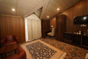 a room with a tv and a chair and a table at hotel gulmarg hills in Gulmarg