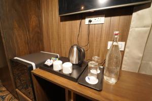 a tray with a kettle and a bottle on a table at hotel gulmarg hills in Gulmarg