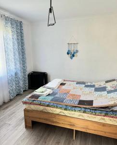a bedroom with a bed with a quilt on it at The Bay Area in Cholpon-Ata +4 photos