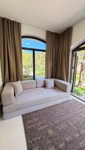 a couch in a room with a large window at Raduga Resort Orion in Chon-Sary-Oy