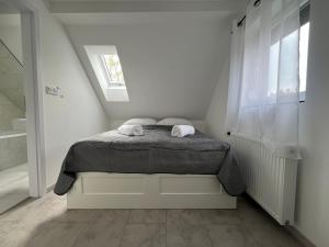a bedroom with a bed with two towels on it at Garda Apartman in Balatonfenyves