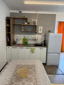 a kitchen with white cabinets and a white refrigerator at The Bay Area in Cholpon-Ata