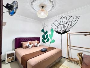 a bedroom with a bed with a flower on the wall at Bromo Breeze Malang in Malang