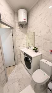 a white bathroom with a toilet and a sink at Raduga Resort Orion in Chon-Sary-Oy +14 photos