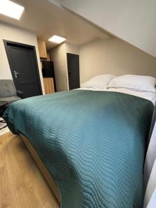 a bedroom with a large bed with a blue blanket at Apartamenty Nad Suwalskim Bulwarem in Suwałki