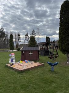 a playground in a park with a play structure at Kuningatalu Palkmaja in Roosisaare