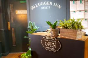 a sign that says open on a counter with plants at The Lugger Inn in Weymouth