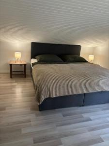 a bedroom with a bed and a table with two lamps at Lakehouse Nour in Bell