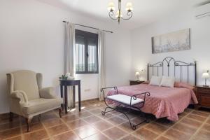 a bedroom with a bed and a chair at La Pedrosa in La Cimada