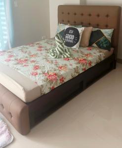 a bed with a floral comforter and a pillow on it at Onelakeshore back smx lanang in Davao City