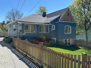 a blue house with a wooden fence at State Street Cottage, Suite 2 in Pullman