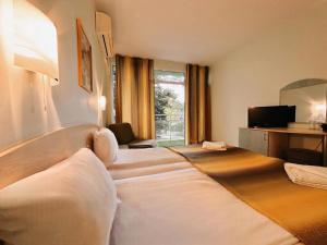 a hotel room with a couch and a television at Dalis Sunny Beach in Sunny Beach