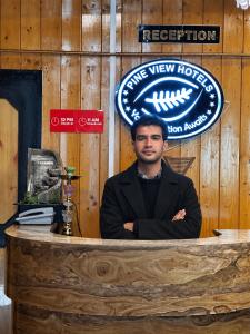 a man sitting at a counter with his arms crossed at Pine view in Gulmarg
