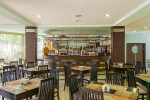 a restaurant with wooden tables and chairs and a bar at Dalis Sunny Beach in Sunny Beach