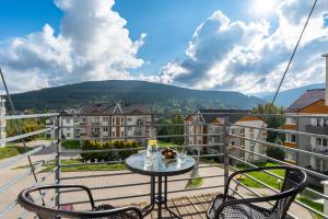 a balcony with two chairs and a table with a view at Apartamenty Izerskie - ul. Cicha 13D-E in Świeradów-Zdrój