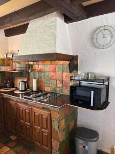 a kitchen with a stove and a clock on the wall at Lakehouse Nour in Bell