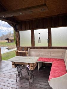 a porch with a bench and a table and windows at Kuningatalu Palkmaja in Roosisaare +27 photos