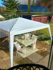 a white canopy over a table and chairs on a deck at Scandinavian Villa near Sea with Sauna 4BR in Söderhamn