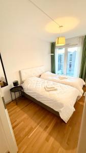 two beds in a bedroom with a wooden floor at Cape Homes St-Sulpice in Saint-Sulpice