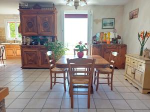 a kitchen with a wooden table with chairs and a table at La Chambre du Bout du Monde in Bouillac