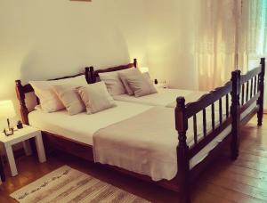a bedroom with two beds with white sheets and pillows at Bistrički mir - Rustic House in Petrovac na Mlavi