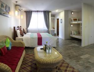 een slaapkamer met een bed, een bank en een tafel bij Hak Boutique Residence in Siem Reap