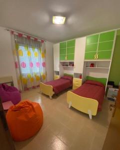 two beds in a room with green and yellow at La Villetta in Giulianova