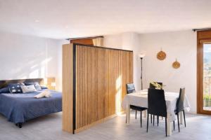 a bedroom with a bed and a table and chairs at Apartament Gritella ( Cim Apartaments ) in Cornudella
