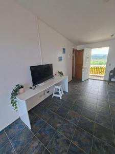 a living room with a tv and a white desk at Hotel La Loma in Miches