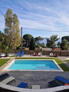 a swimming pool in a yard with chairs around it at La Maison Fratelli in Hyères +30 photos