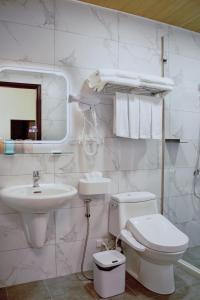 a white bathroom with a toilet and a sink at Up villa in Taibao +14 photos