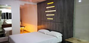 a bedroom with a bed and a wall with lights at Alpino Motel by Drops in Jundiaí