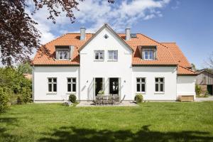 a white house with an orange roof at Kleiner Caecilienhof in Pommerby