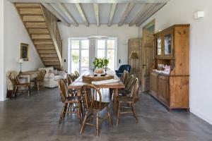 a dining room with a wooden table and chairs at Kleiner Caecilienhof in Pommerby +23 photos