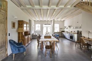 a kitchen and dining room with a table and chairs at Kleiner Caecilienhof in Pommerby