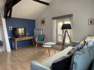 a living room with a couch and a tv at Maison Cahors in Cahors