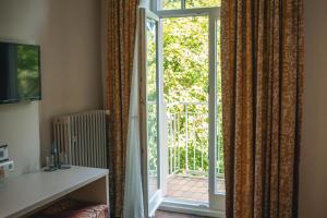 a room with a sliding glass door to a patio at LU8 Business Vital Hotel in Bad Dürrheim